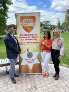 Man and two Women posing with the pride of andover unsung heroes banner
